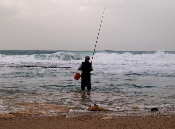 Одинокий рыбак с удочкой и ведром
